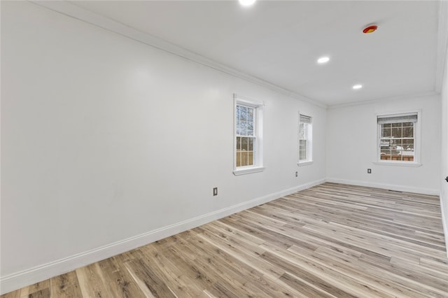 empty room featuring recessed lighting, light wood-style flooring, crown molding, and baseboards