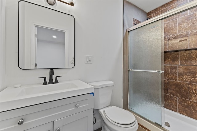 full bath featuring vanity, toilet, and a stall shower