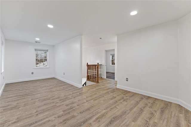 empty room featuring light wood finished floors, visible vents, recessed lighting, and baseboards