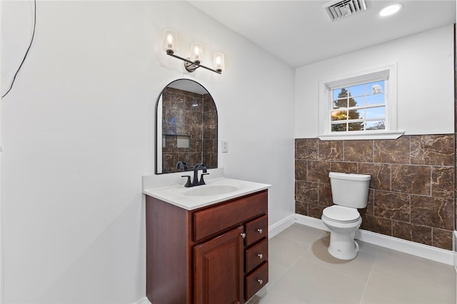 bathroom featuring visible vents, toilet, tile walls, tile patterned flooring, and vanity