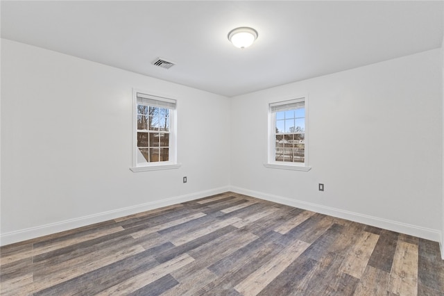 spare room with visible vents, wood finished floors, and baseboards