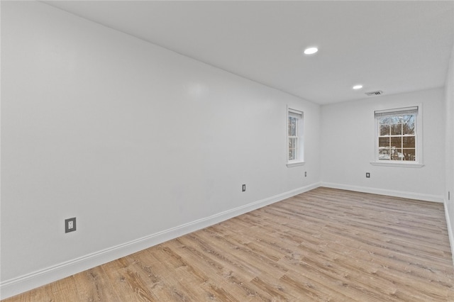 unfurnished room with visible vents, recessed lighting, light wood-type flooring, and baseboards