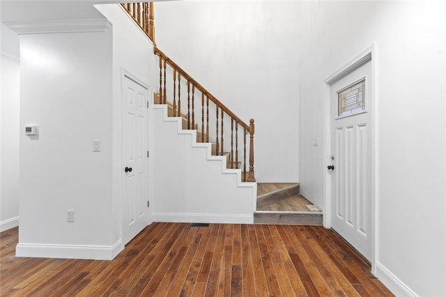 foyer entrance featuring stairs, baseboards, and hardwood / wood-style floors