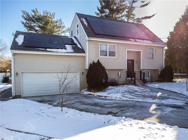 view of front facade with solar panels and a garage