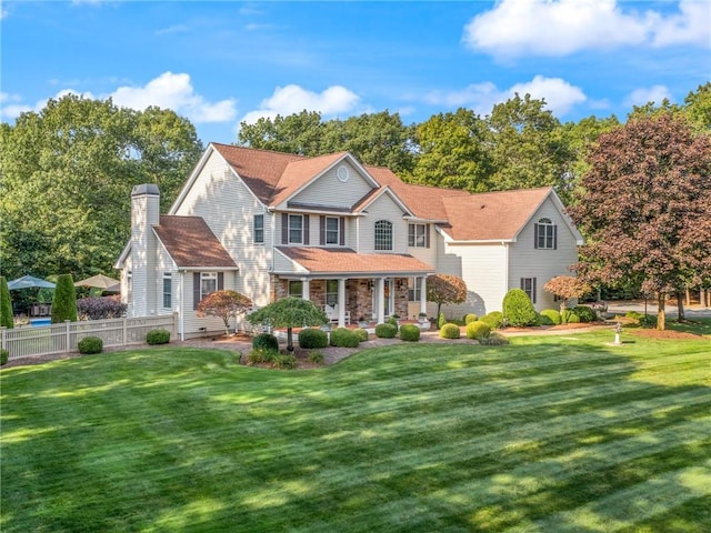 view of front of home with a front lawn, fence, and a chimney