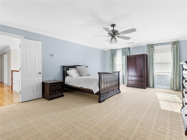 bedroom with light carpet, multiple windows, a ceiling fan, and ornamental molding