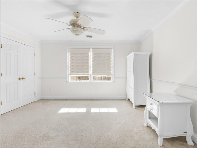 unfurnished bedroom featuring visible vents, baseboards, light colored carpet, and crown molding