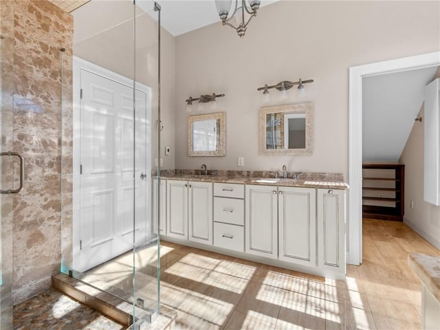 bathroom featuring a sink, a shower stall, and double vanity