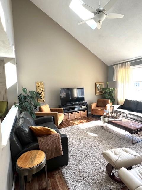 living room featuring a ceiling fan, wood finished floors, and high vaulted ceiling