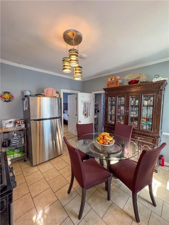 dining space featuring light tile patterned flooring and ornamental molding