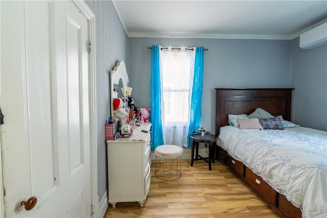 bedroom featuring light wood-style flooring, a wall mounted air conditioner, and ornamental molding