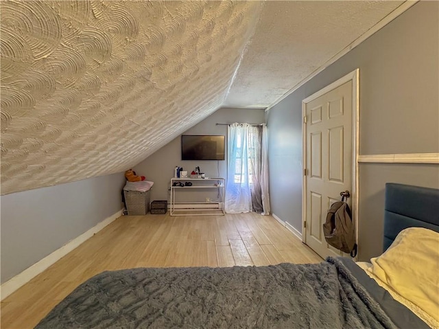 additional living space with vaulted ceiling, a textured ceiling, baseboards, and wood finished floors