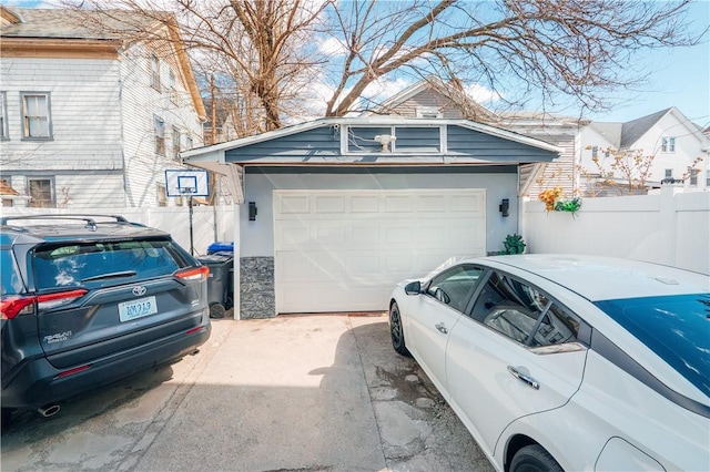 garage featuring fence and driveway