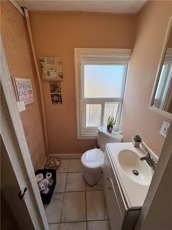 bathroom with tile patterned flooring, toilet, vanity, and baseboards