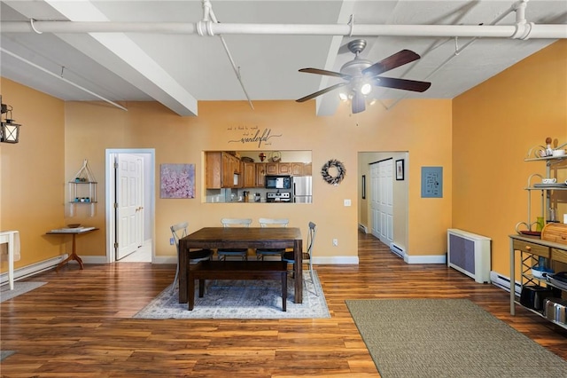 dining room featuring radiator, baseboards, beamed ceiling, baseboard heating, and wood finished floors