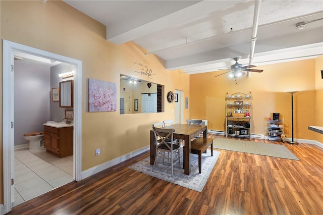 dining room with baseboards, beam ceiling, wood finished floors, and a ceiling fan