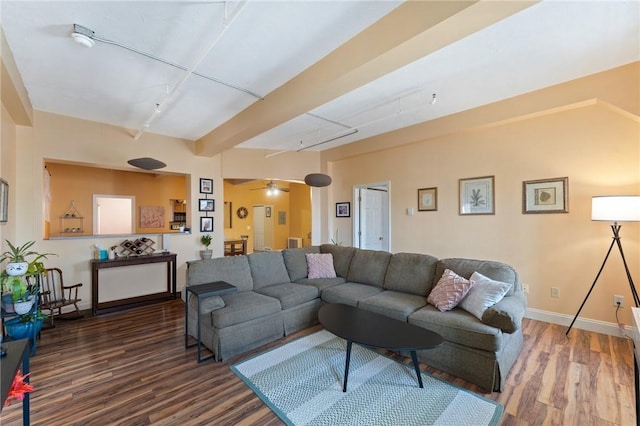 living room featuring beamed ceiling, baseboards, wood finished floors, and a ceiling fan