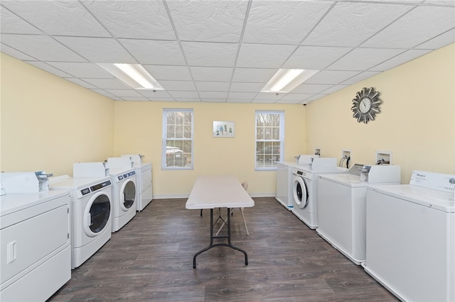 shared laundry area featuring dark wood-type flooring, washing machine and dryer, and baseboards