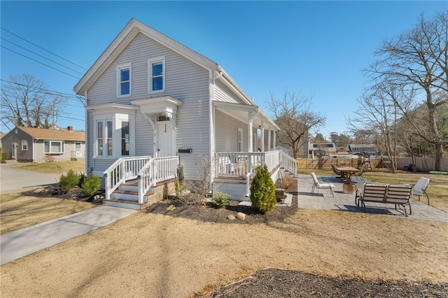 view of front facade featuring fence and a patio area