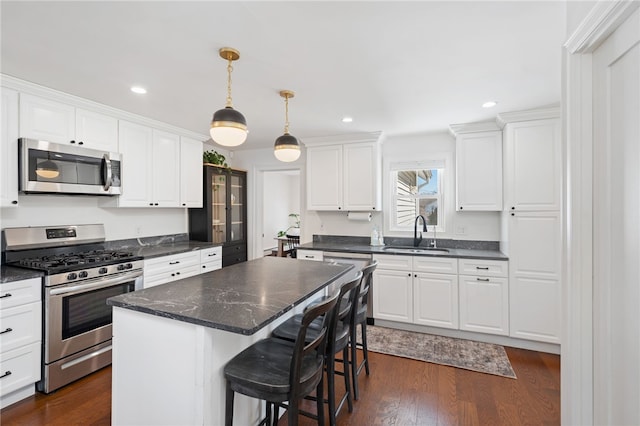 kitchen with white cabinetry, stainless steel appliances, and a sink