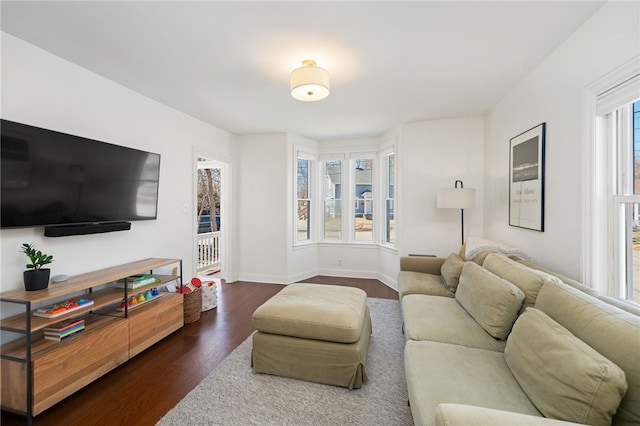 living room with baseboards and dark wood-style flooring