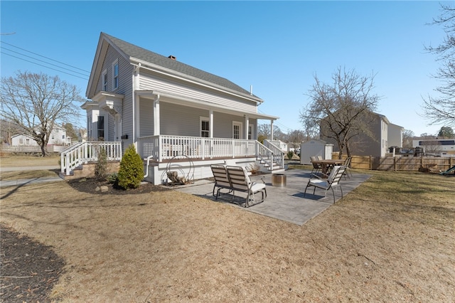 back of house with a patio, fence, a porch, an outdoor structure, and a storage unit