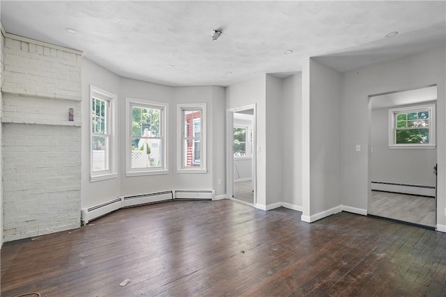 unfurnished room featuring a baseboard heating unit, baseboards, and hardwood / wood-style floors