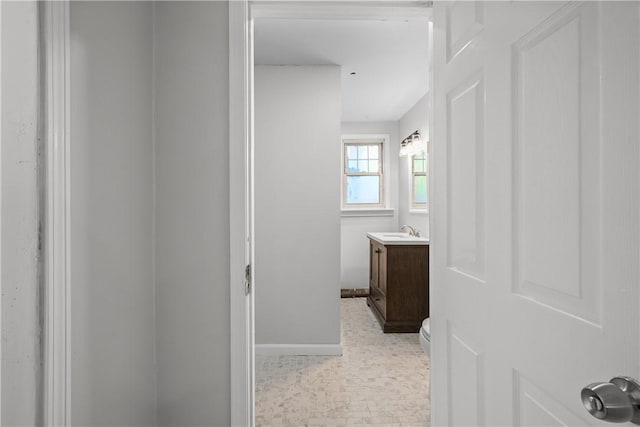 bathroom featuring baseboards, toilet, and vanity