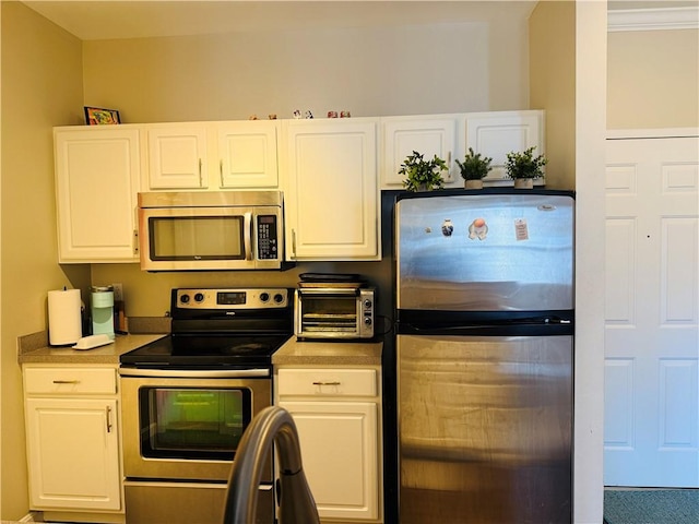 kitchen featuring a toaster, white cabinets, appliances with stainless steel finishes, and light countertops