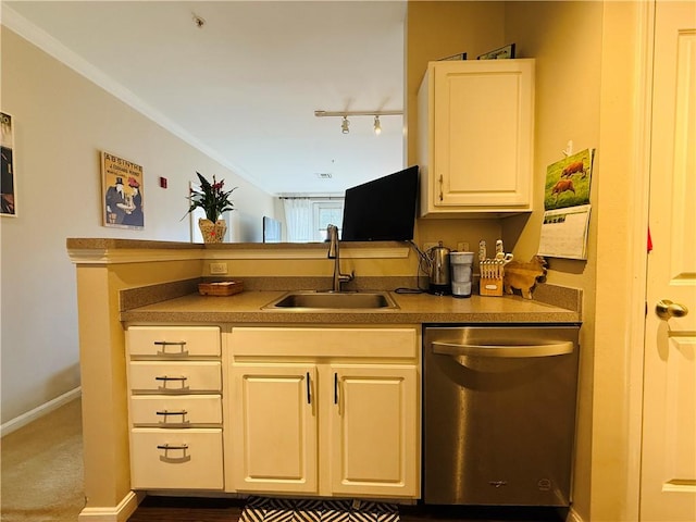 kitchen featuring baseboards, rail lighting, a peninsula, stainless steel dishwasher, and a sink