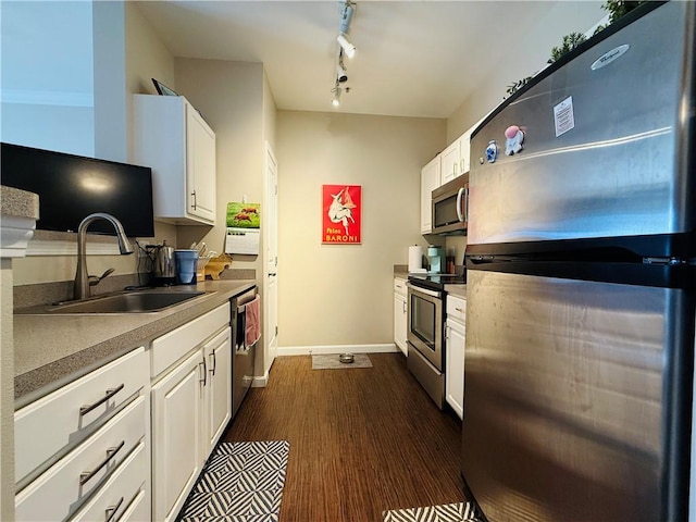 kitchen featuring a sink, baseboards, stainless steel appliances, white cabinetry, and dark wood-style flooring