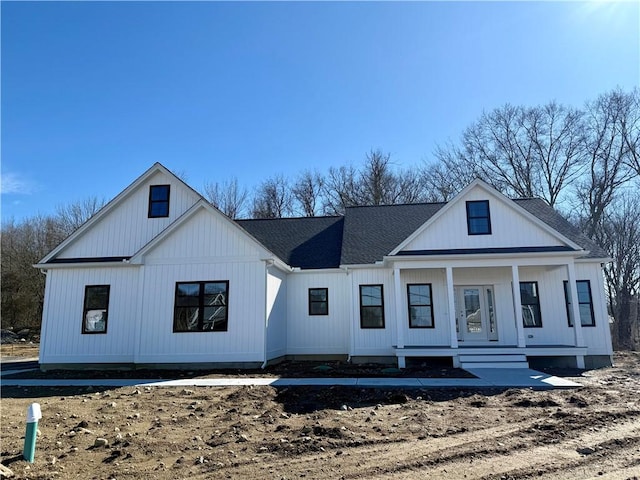 modern farmhouse style home featuring roof with shingles and covered porch