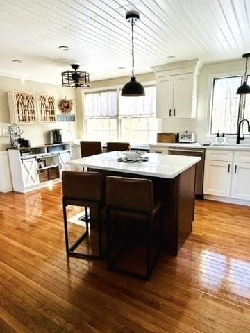 bar featuring hardwood / wood-style floors, decorative light fixtures, wood ceiling, and a sink