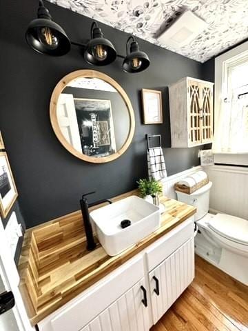 bathroom featuring toilet, vanity, and wood finished floors