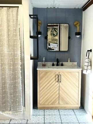 bathroom with tile patterned floors, curtained shower, and vanity