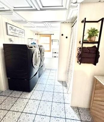 laundry room featuring light tile patterned flooring, washing machine and dryer, and laundry area