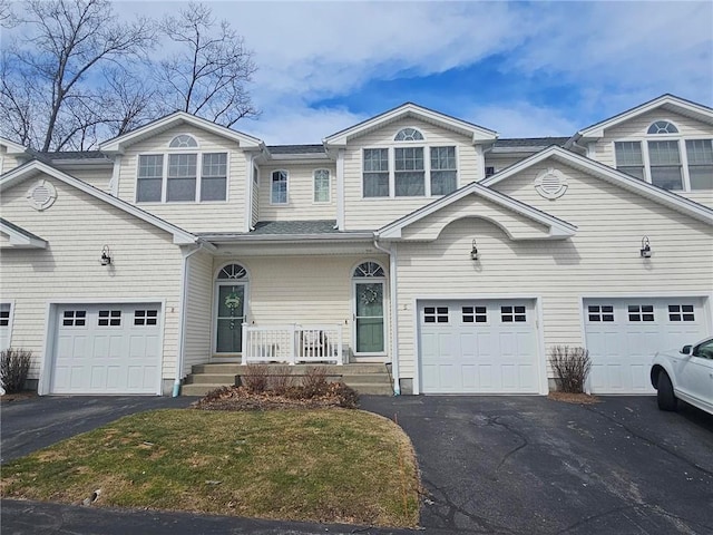 view of front of home with a porch, an attached garage, and driveway