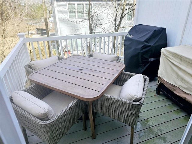 wooden deck with outdoor dining area and grilling area