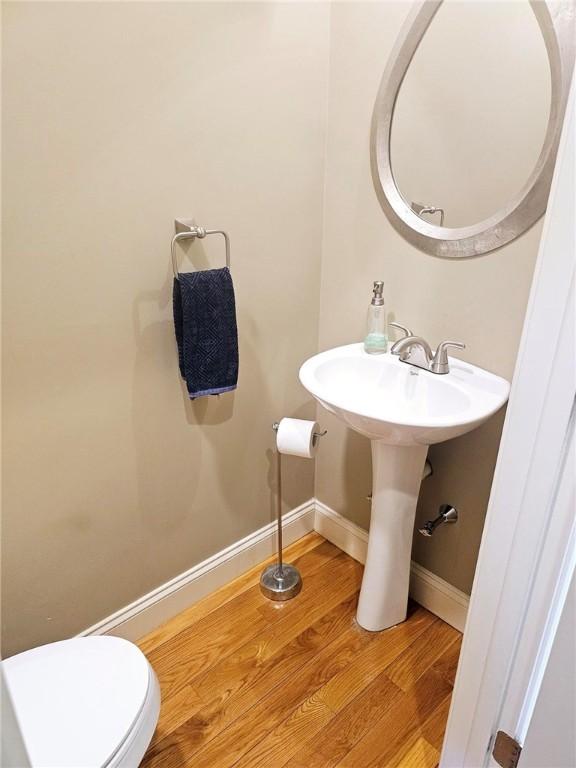 bathroom featuring toilet, baseboards, and wood finished floors