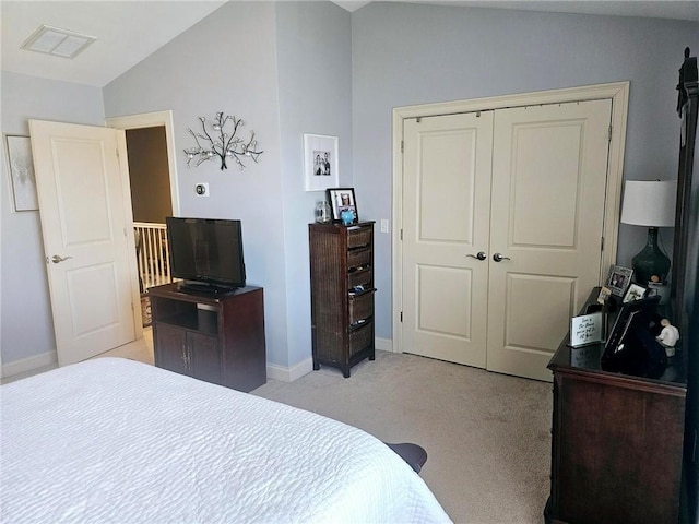 bedroom featuring visible vents, a closet, baseboards, light colored carpet, and vaulted ceiling