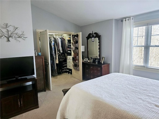 bedroom with vaulted ceiling, light colored carpet, and a closet