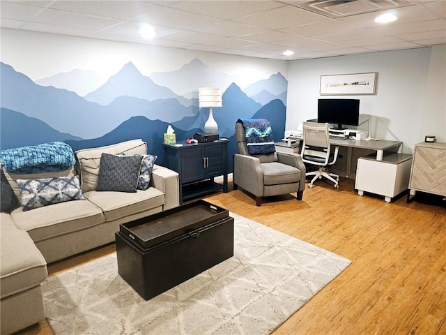 living room with wood finished floors, visible vents, and a drop ceiling