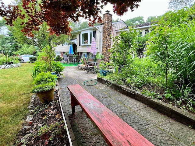 view of home's community with a yard and a patio