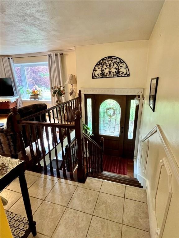 tiled foyer entrance featuring a textured ceiling