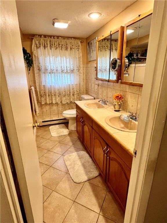 bathroom with tile patterned floors, toilet, a baseboard radiator, and a sink