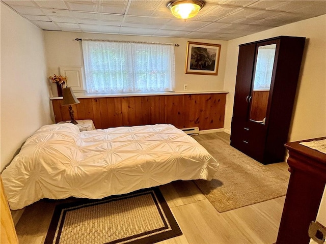 bedroom with a baseboard radiator and wood finished floors