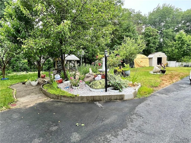 view of property's community with a gazebo, a shed, a lawn, and an outdoor structure