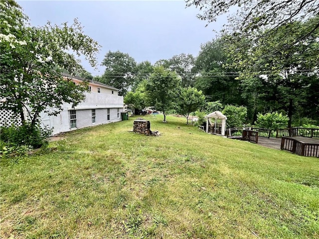 view of yard featuring a wooden deck and an outdoor fire pit