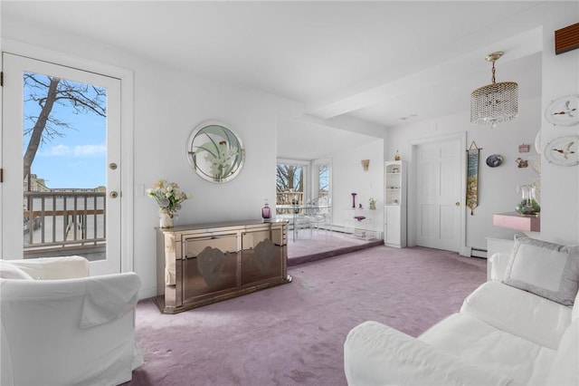 carpeted living area with a baseboard heating unit and baseboards