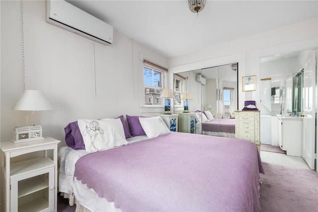 carpeted bedroom with an AC wall unit, a closet, and ensuite bathroom